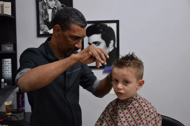 Cabeleireiro cortando o cabelo de uma criança